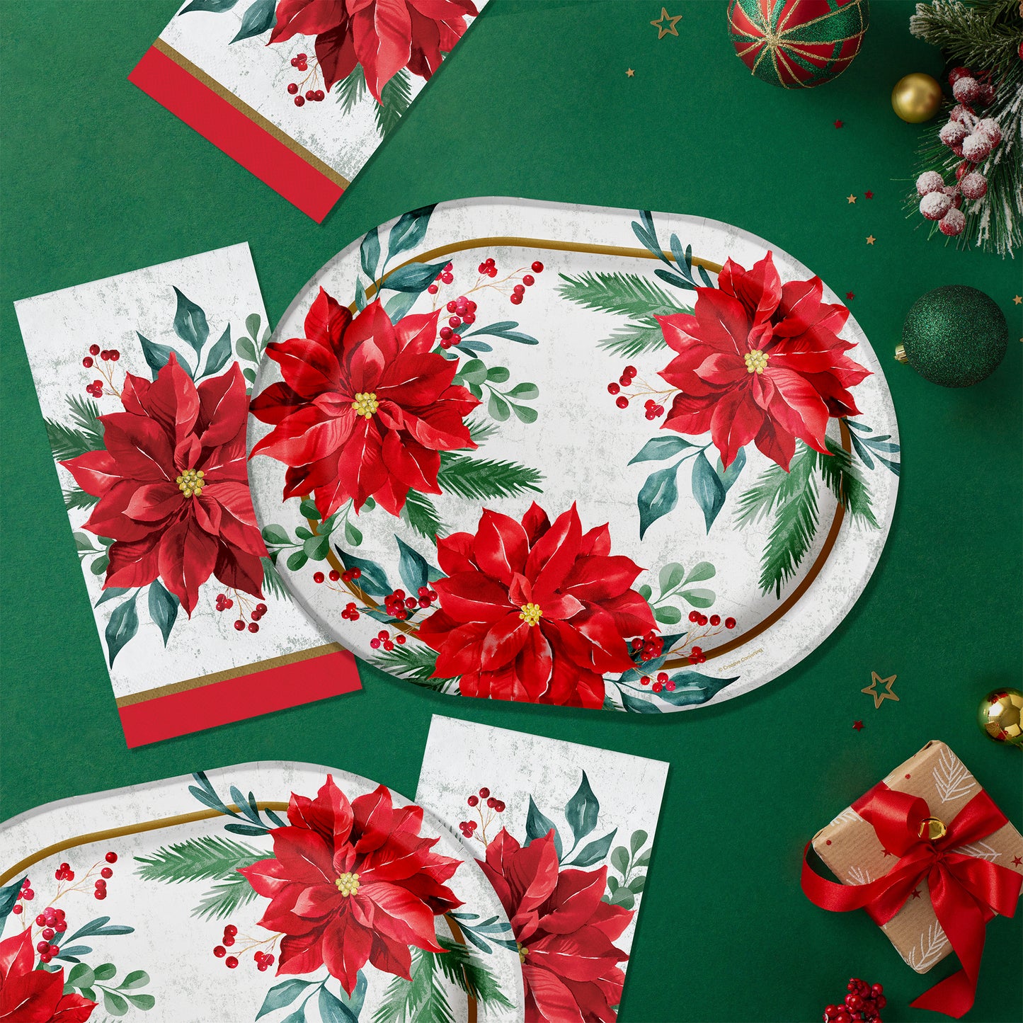 Christmas-themed paper plates and napkins with poinsettia design on a green background.