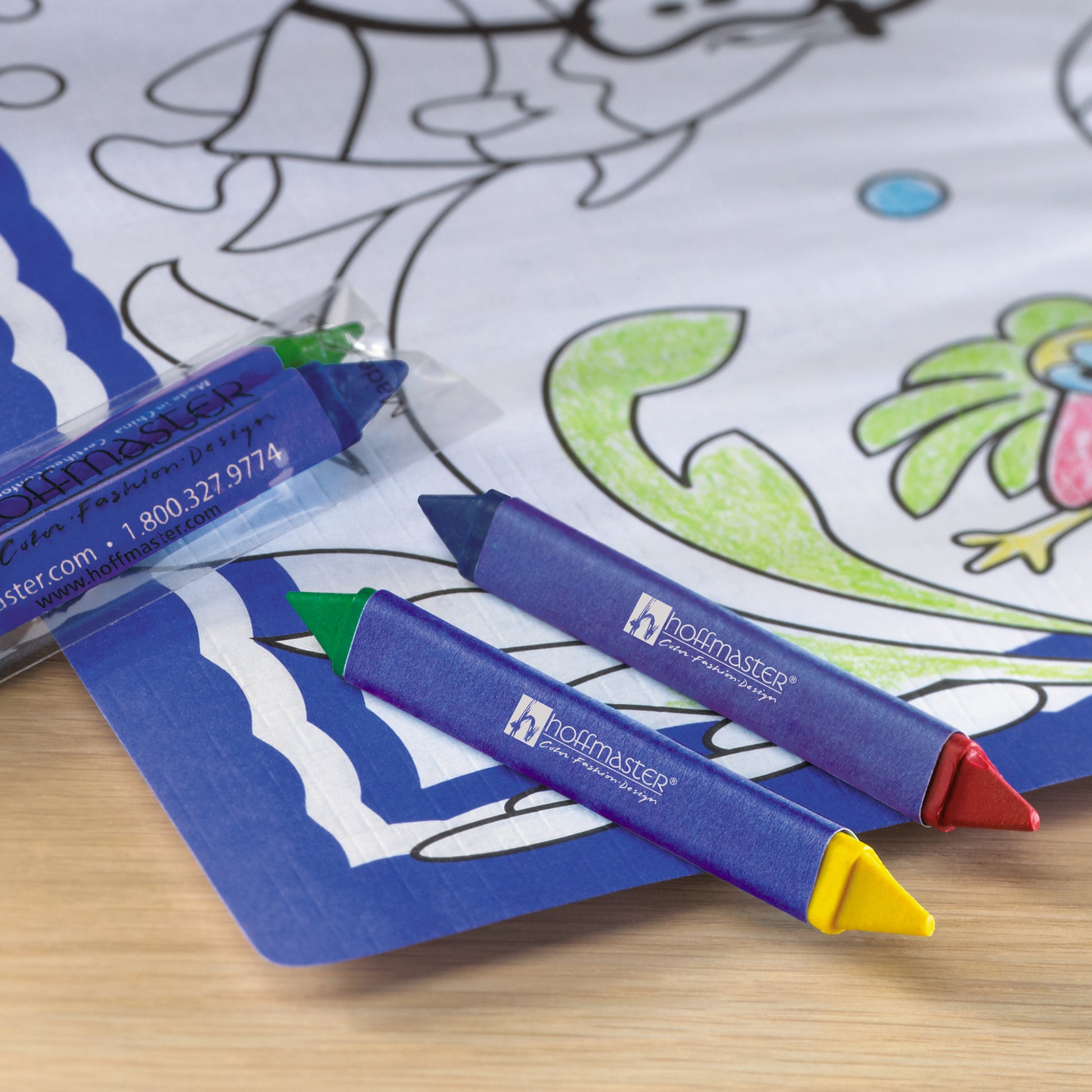 Coloring book with triangular crayons on a wooden surface