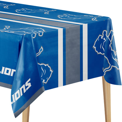 Close-up image of Detroit Lions tablecloth with blue background, Lions logo, and "LIONS" text on a wooden table.