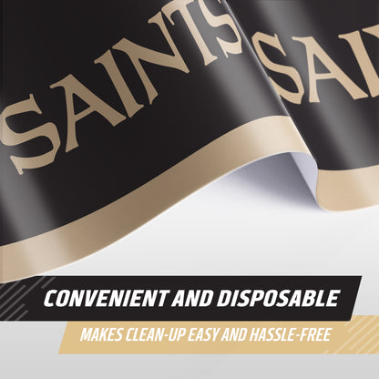 A close-up of a New Orleans tablecloth featuring the word 'SAINTS' in large gold lettering, with text overlays reading 'CONVENIENT AND DISPOSABLE' and 'MAKES CLEAN-UP EASY AND HASSLE-FREE'.