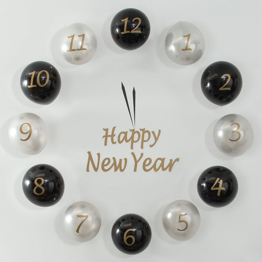 Decorative countdown clock with numbered black and silver balloons spelling 'Happy New Year' on a light background