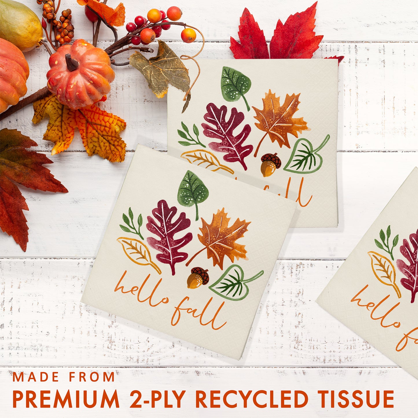 Fall Festivities Thanksgiving Beverage Napkins 192 ct. Paper napkins with autumn leaf designs and 'hello fall' text on a white wooden surface with decorative pumpkins and leaves.