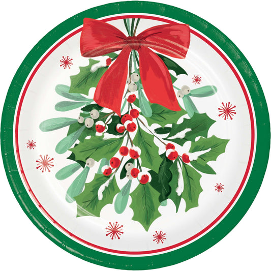 Round Christmas-themed paper plate with holly leaves, berries, and a red bow on a white background.