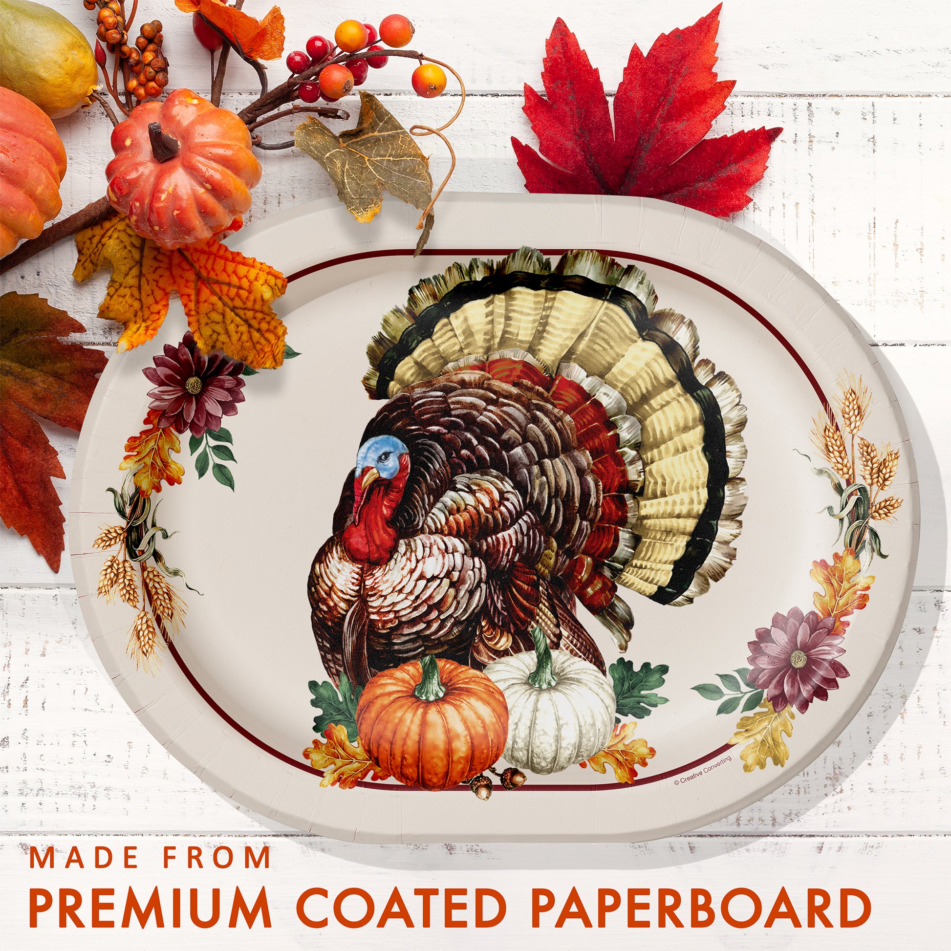 Vintage Turkey Oval Dinner Paper Plates 96 ct. Decorative plate with a turkey design, surrounded by autumn leaves and pumpkins on a white background.