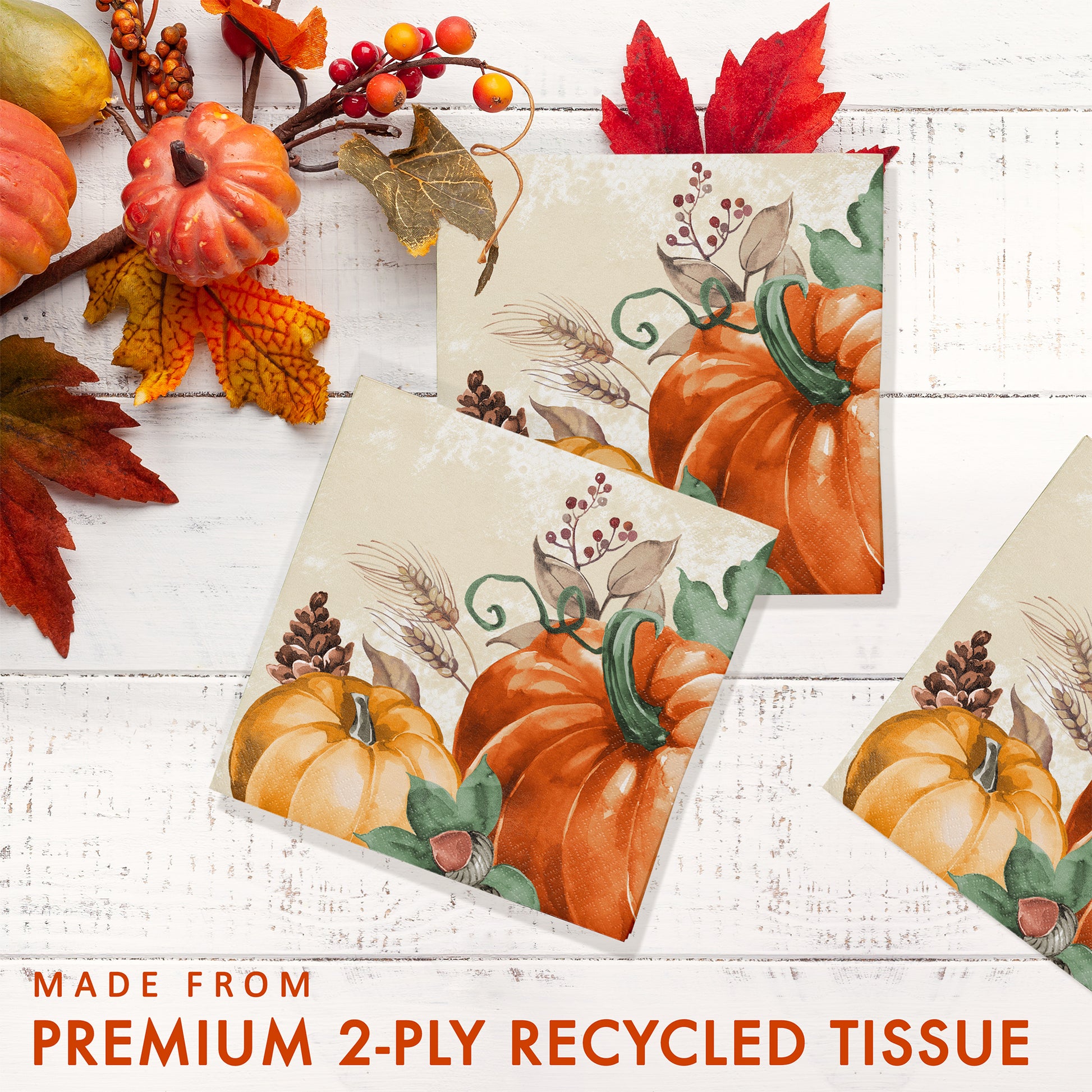 Harvest Delight Beverage Napkins 192 ct. Decorative paper napkin with pumpkins and autumn leaves on a white wooden surface, labeled as made from premium 2-ply recycled tissue.