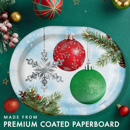 Decorative paper plate with Christmas ornaments on a green background with holiday decorations and greenery