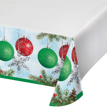 Christmas-themed paper tablecloth with ornaments, snowflakes, and evergreen branches on a white background.