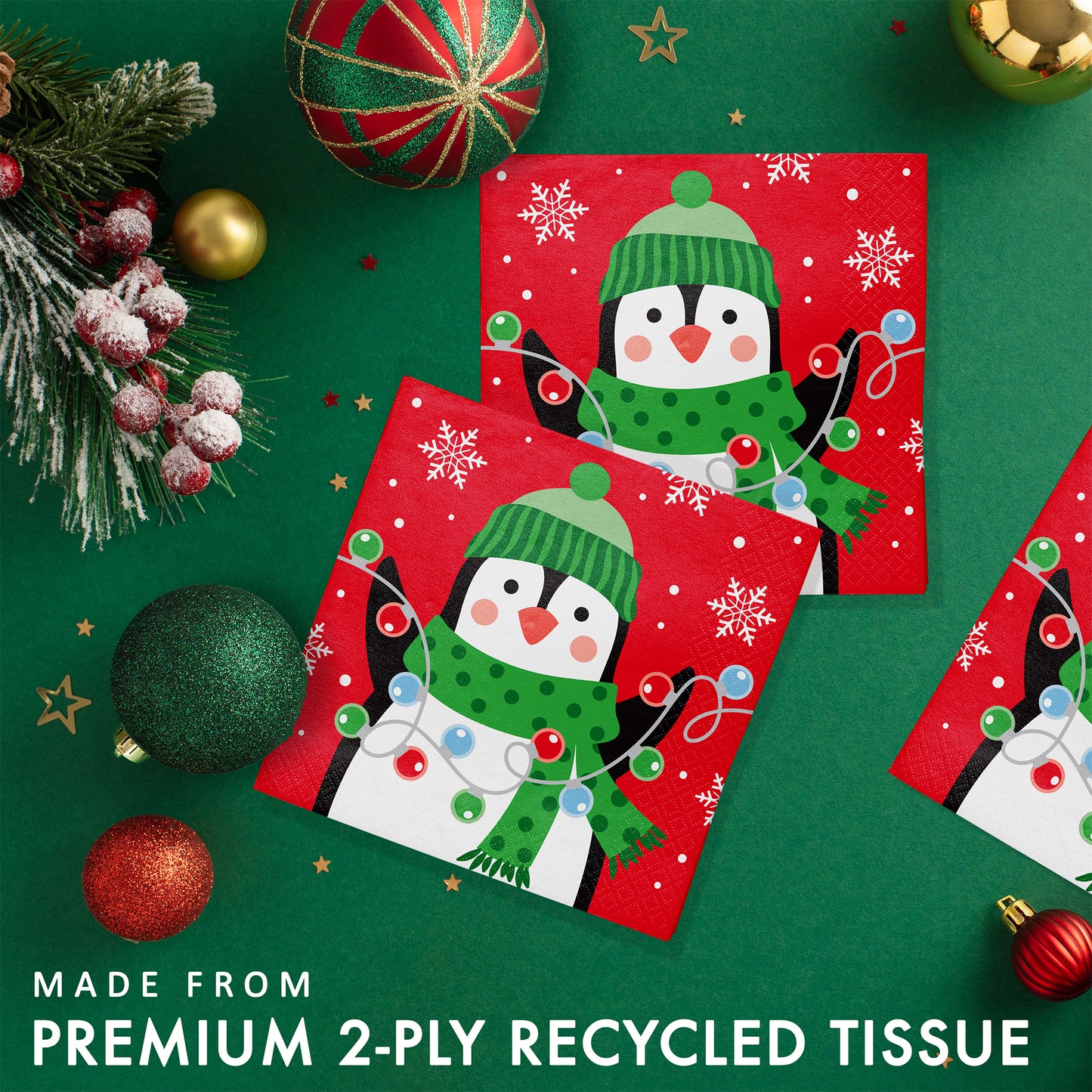 Christmas Cheer Beverage Napkins 192 ct. Christmas-themed paper napkins with penguin design on a green background with ornaments.