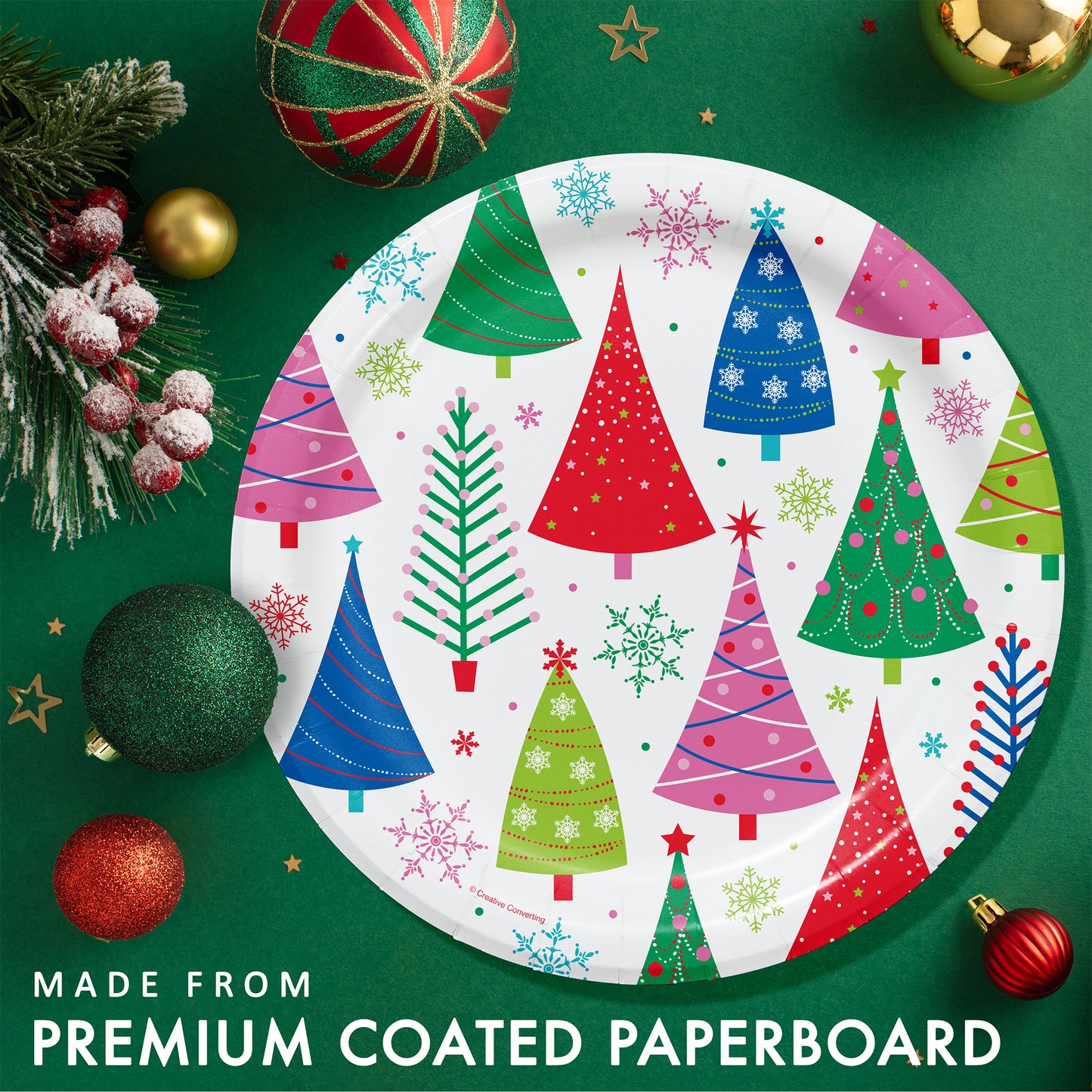Joyful and Jolly Dinner Paper Plates 96 ct. White paper plate with colorful festive Christmas trees on a green background with Christmas decorations