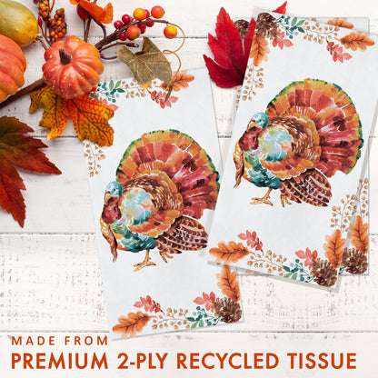 Tasteful Turkey Dinner Napkins 192 ct. Two sheets of decorative tissue paper with turkeys and autumn leaves on a white wooden surface.