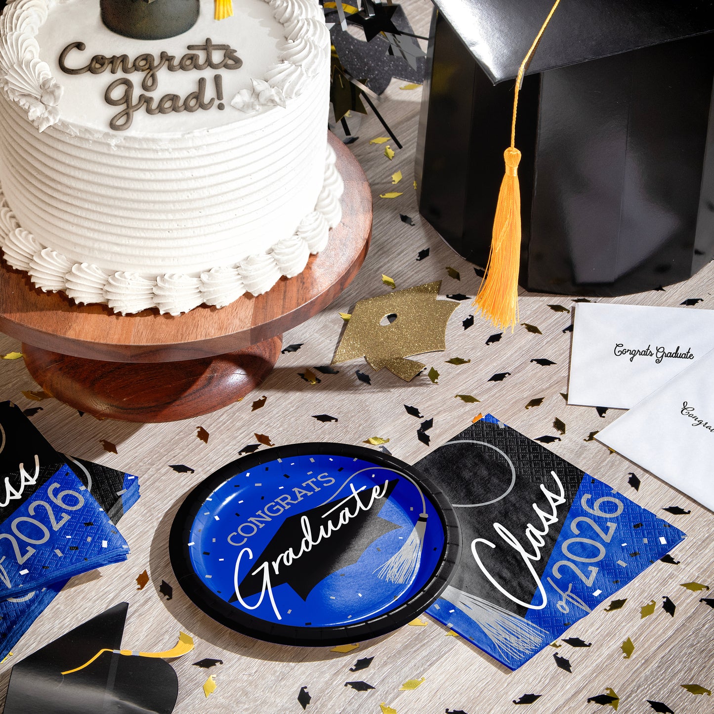Graduation-themed table setting with cake, cap, and 'Congrats Grad!' decorations.