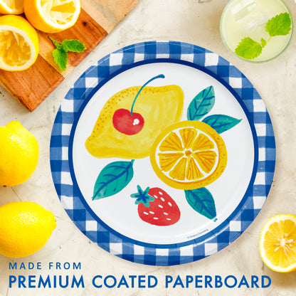 Decorative paper plate with fruit design on a checkered border, surrounded by lemons and mint leaves.