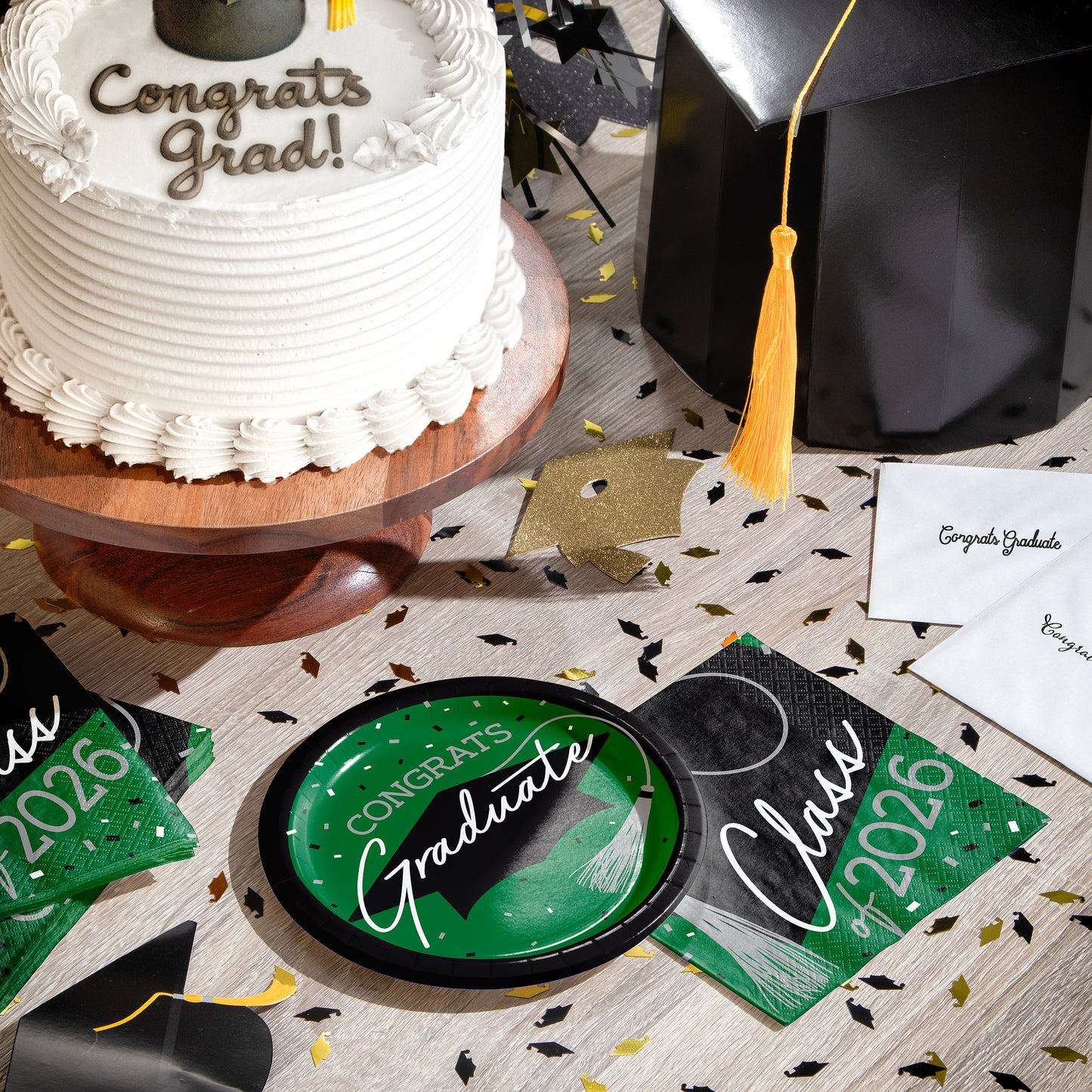 Graduation-themed table setting with cake, cap, plate, napkins and graduation decorations