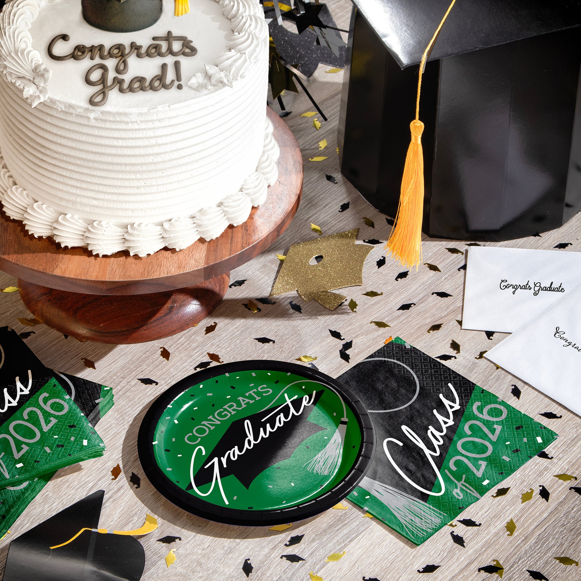 Graduation-themed table setting with cake, cap, plate, napkins and graduation decorations