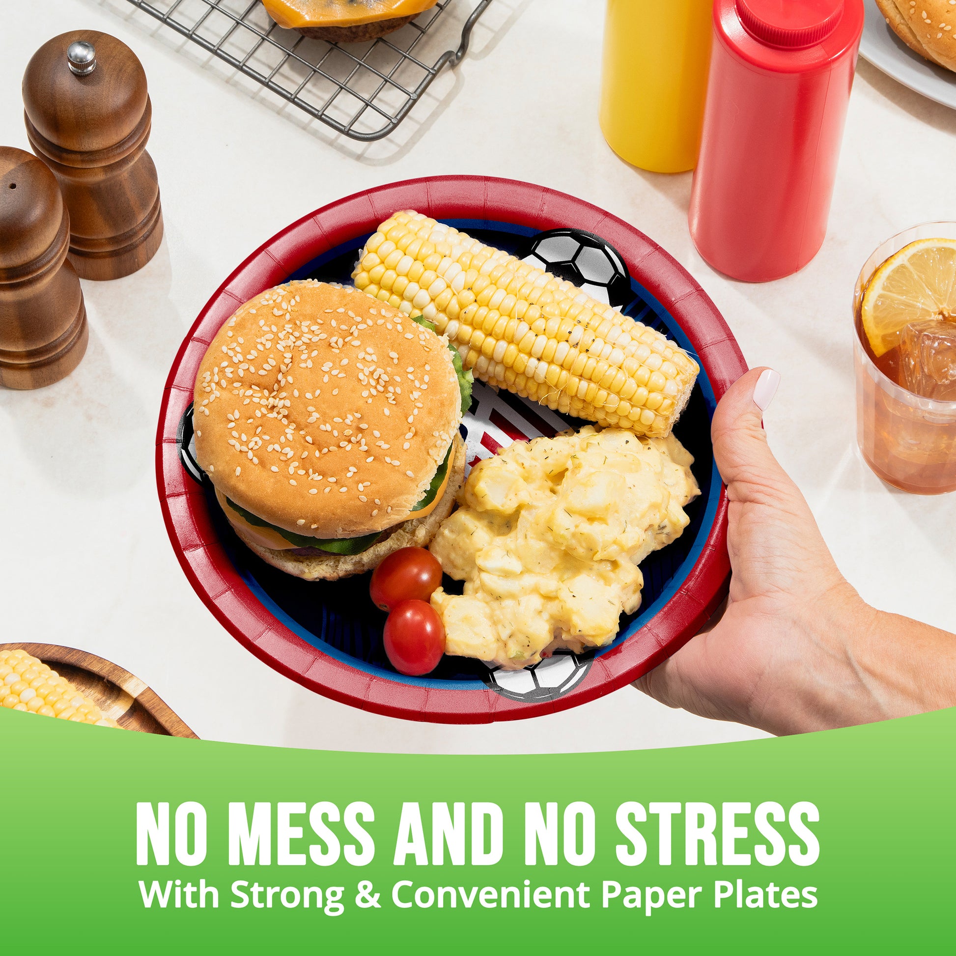 Hand holding a blue and red plate with a burger, corn on the cob, and potatoes, with text 'No Mess and No Stress with Strong & Convenient Paper Plates'.