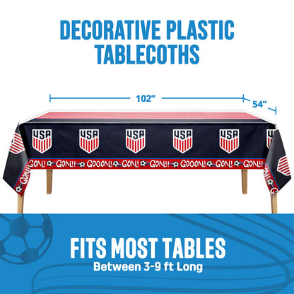 Tablecloth on a wooden table with USA sports team logo and 'GOAL!' text on a white background with text 'Decorative plastic tablecloths' and 'Fits most tables between 3-9 ft. long'. Measurements shown.