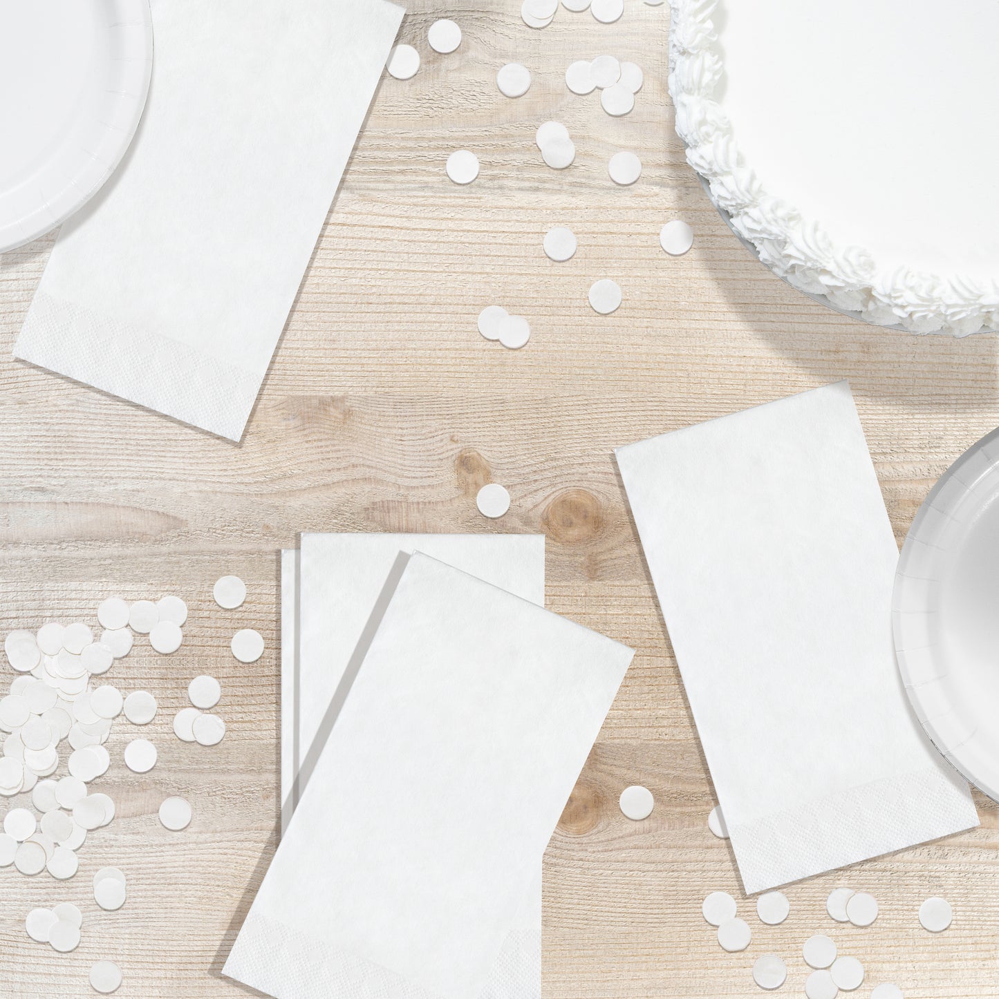 White napkins and confetti on a wooden table