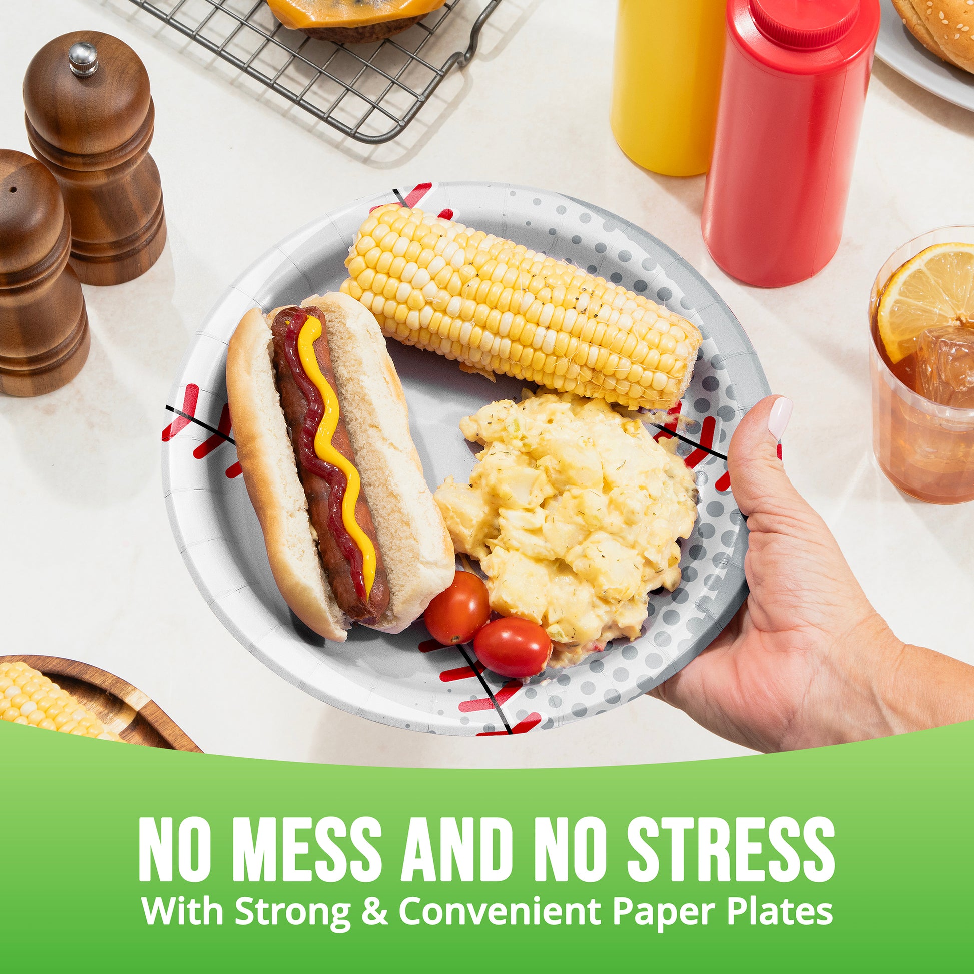 Plate of food with a hot dog, corn on the cob, and mashed potatoes, held by a hand, with text 'No Mess and No Stress'.