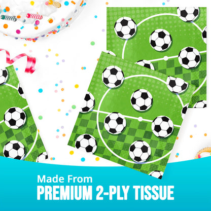 Soccer-themed tissue paper napkin with green field and black and white soccer balls. Shown on a white table with colorful confetti.