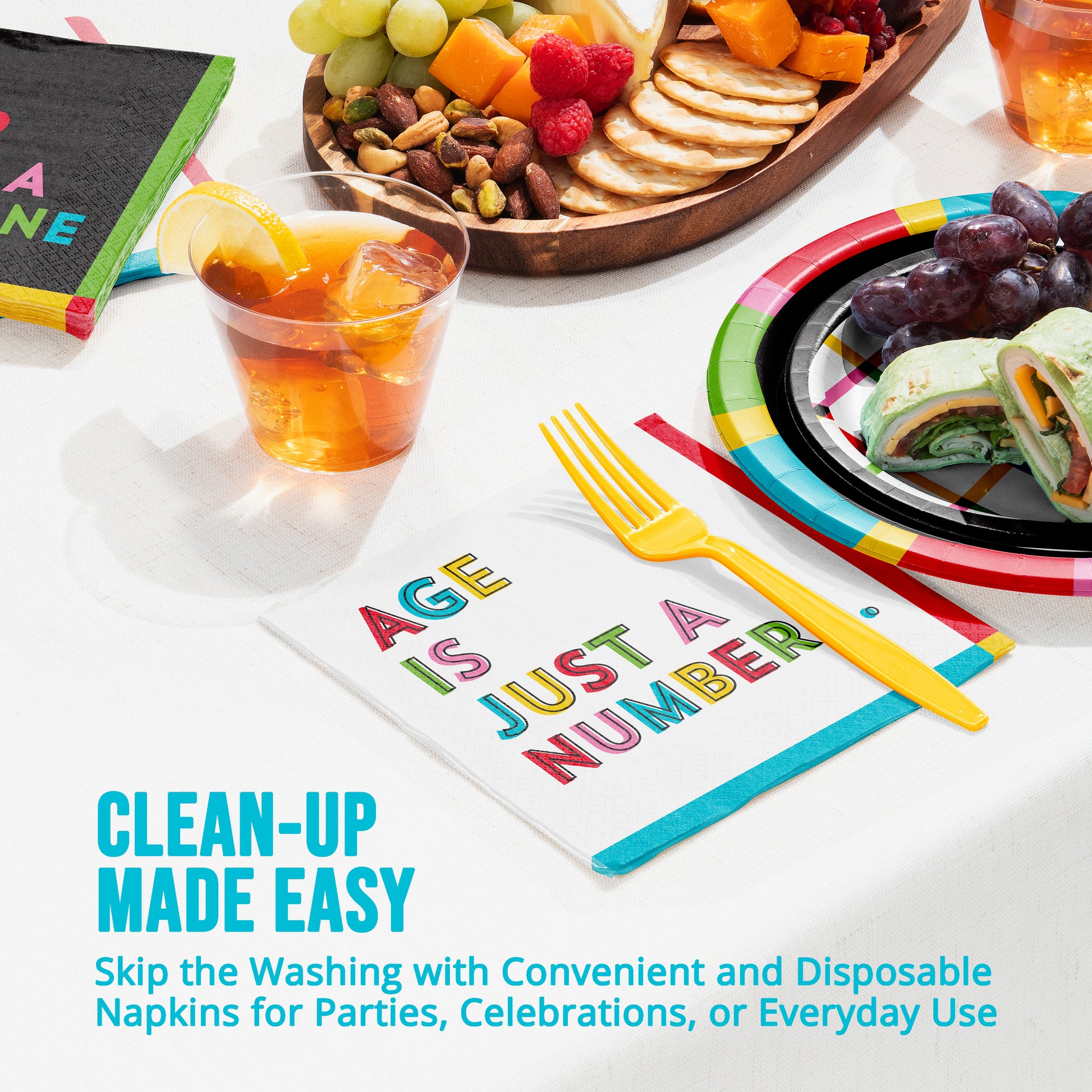 Disposable napkins with colorful text and a plate of food on a table.