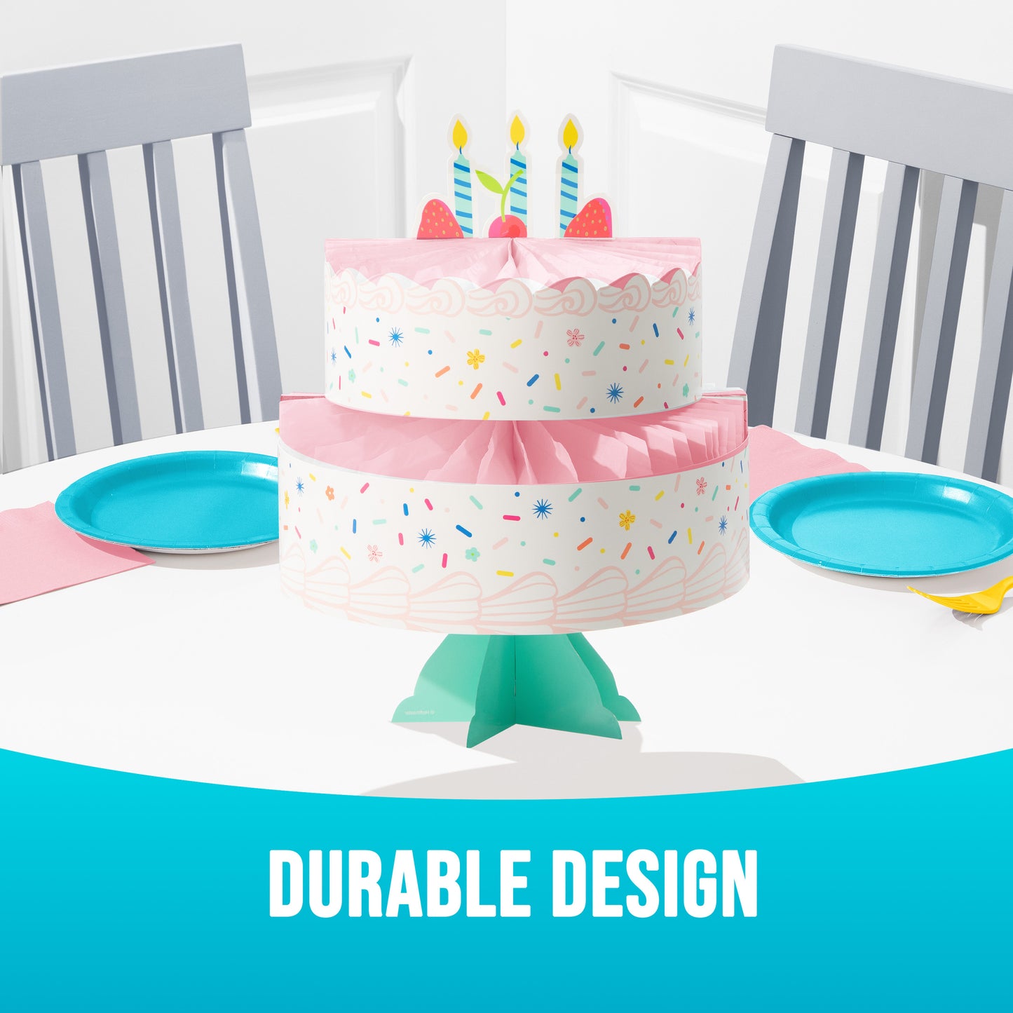 Two-tiered birthday cake stand with colorful sprinkles on a table with blue plates and gray chairs, text 'Durable Design' at the bottom.