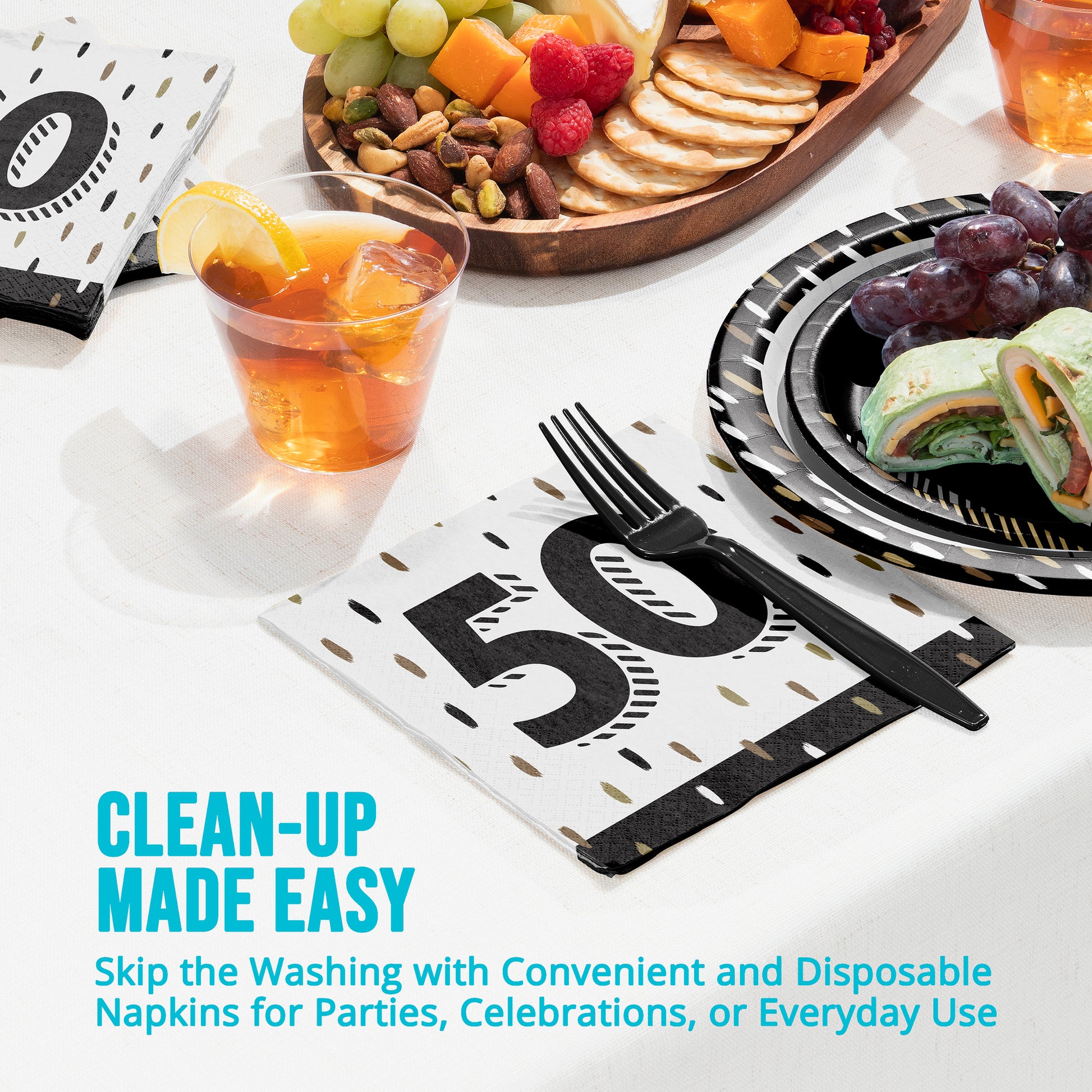 Disposable napkins with a number 50 design on a table setting with food and drinks.