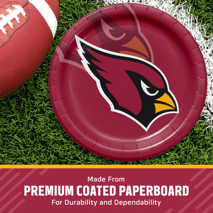 A round red paper plate with the Arizona Cardinals bird logo, shown on a grassy field with a football partially visible. A banner at the bottom reads 'Made From PREMIUM COATED PAPERBOARD For Durability and Dependability'.