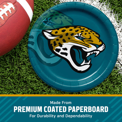 A round teal Jacksonville Jaguars paper plate with the team jaguar logo, shown on a grassy field with a football partially visible. A teal banner at the bottom reads 'Made From PREMIUM COATED PAPERBOARD For Durability and Dependability'.