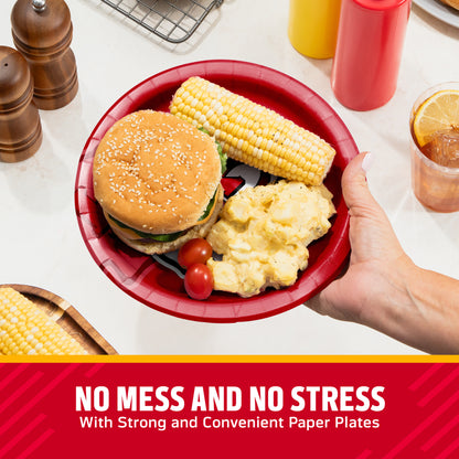 Hand holding a Kansas City Chiefs plate filled with a hamburger, corn on the cob, and potato salad. Banner with "No Mess and No Stress" text along the bottom.