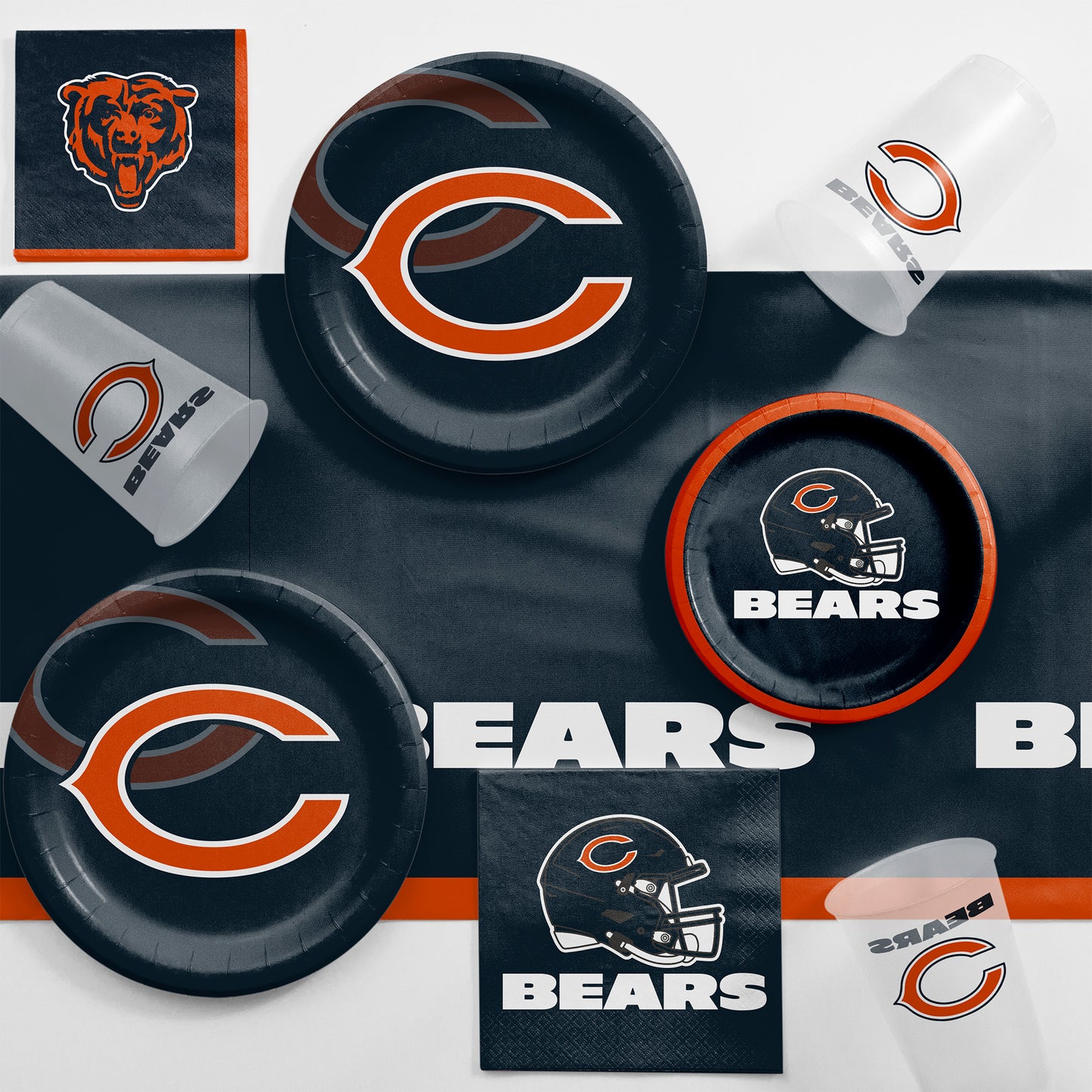 Collection of Chicago Bears-themed party supplies including plates, cups, and napkins on a navy blue tablecloth.
