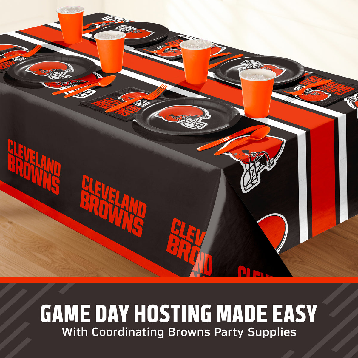 Cleveland Browns themed party table setting with a printed tablecloth, matching plates, cups, and utensils, shown on a table with a promotional banner at the bottom that says "Game Day Hosting Made Easy".