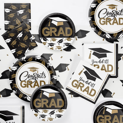 Graduation-themed party supplies including plates, napkins, and banners with 'GRAD' and 'Congrats GRAD' text.