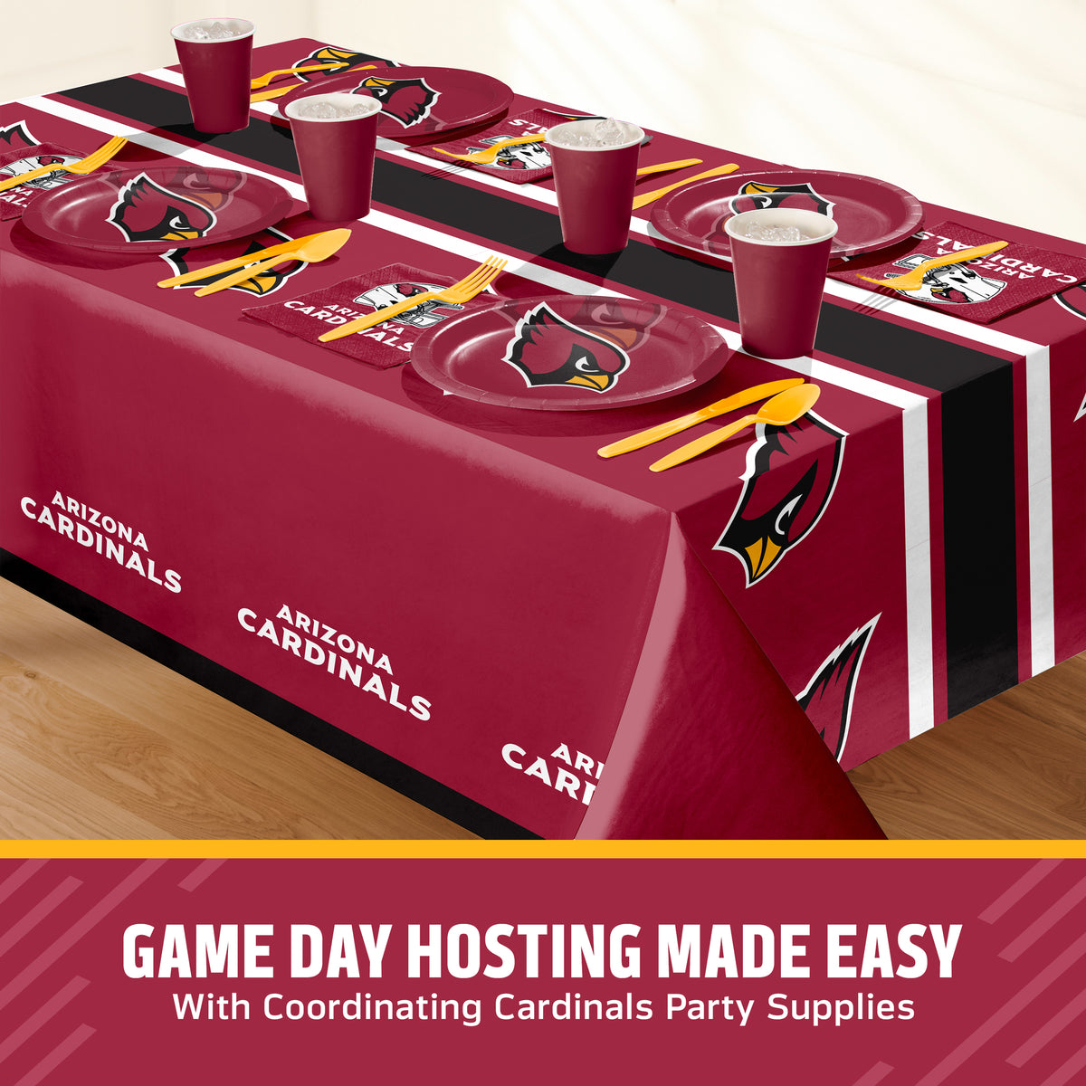 Arizona Cardinals themed party table setting with a maroon tablecloth, matching plates, cups, and yellow utensils, shown on a table with a promotional banner at the bottom with "Game Day Hosting Made Easy with Coordinating Cardinals Party Supplies" text.