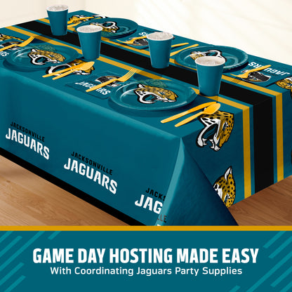 A Jacksonville Jaguars themed party table setting featuring a teal, black, and gold printed tablecloth, matching plates, cups, and utensils, displayed on a wooden floor with a promotional banner at the bottom with 'GAME DAY HOSTING MADE EASY' text.