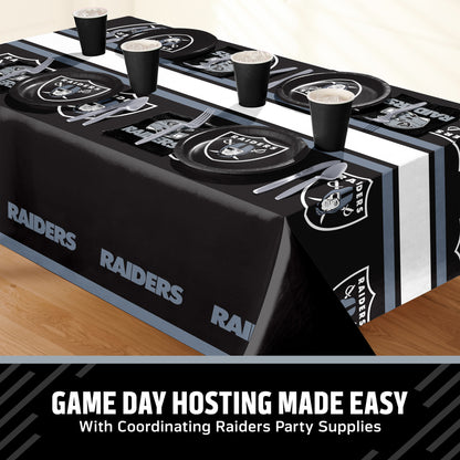 Las Vegas Raiders themed party table setting with a printed tablecloth, matching plates, cups, and utensils, shown on a table with a promotional banner at the bottom that says "Game Day Hosting Made Easy".