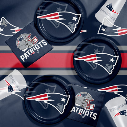 New England Patriots-themed party supplies including plates, napkins, and cups on a dark background.