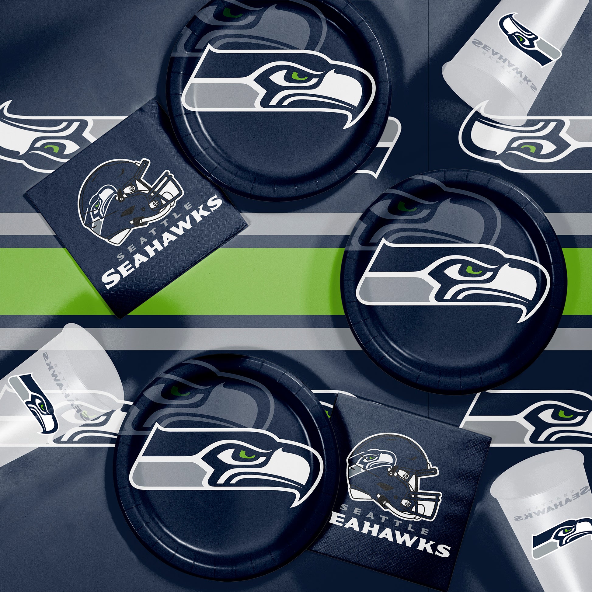 Collection of Seattle Seahawks-themed party supplies including plates, cups, and napkins on a dark background.
