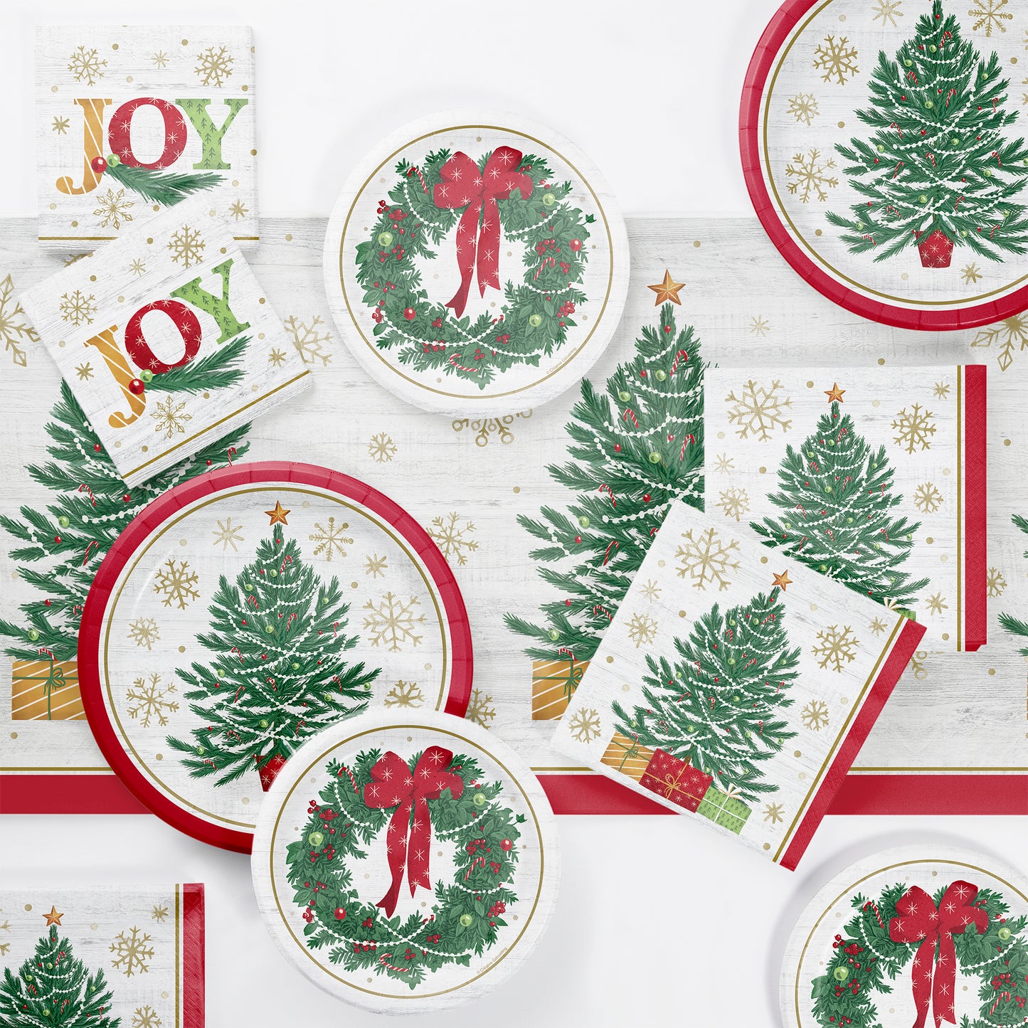 Christmas-themed paper plates and napkins with trees, wreaths, and 'JOY' text on a white background.